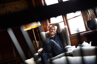 Fredrik Brännlund, founder of Noa The Game Fredrik Brännlund smiling, leaning back in an armchair with an arm over his head
