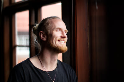 Fredrik Brännlund, founder of Noa The Game Fredrik Brännlund smiling and looking upward by a window in backlight