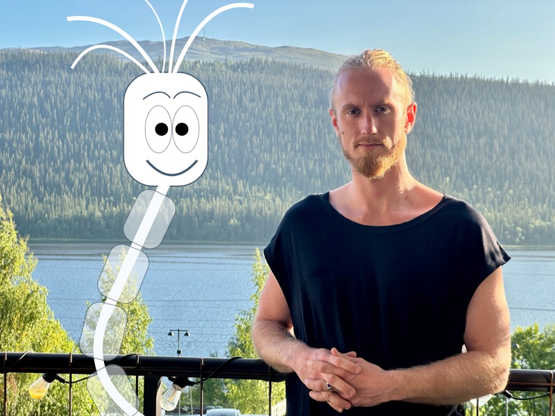 Fredrik Brännlund with Noa Fredrik Brännlund holding up Noa, the nerve cell the game is named after, in front of the mountain and the lake